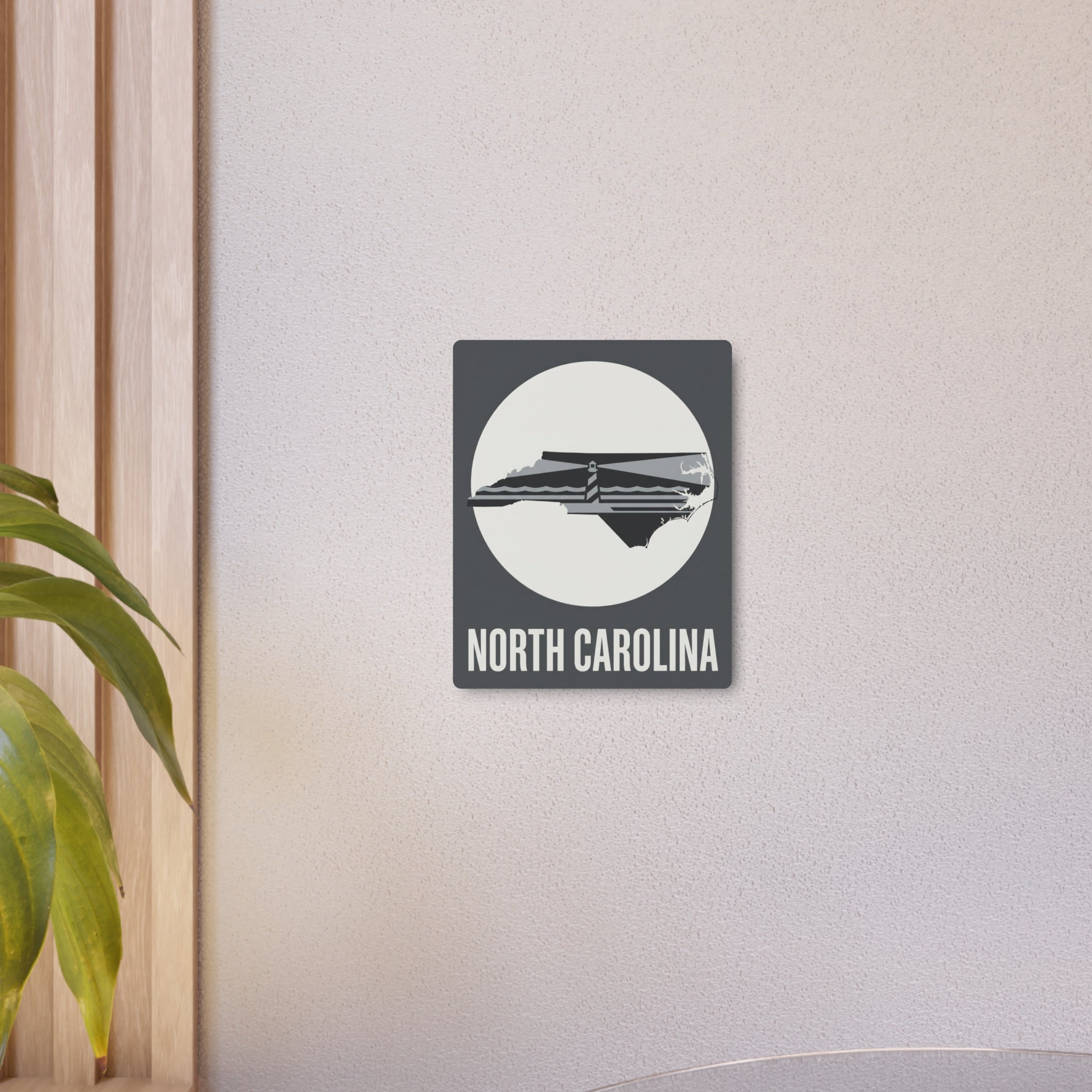 North Carolina lighthouse metal wall sign on light wall, centered decor piece