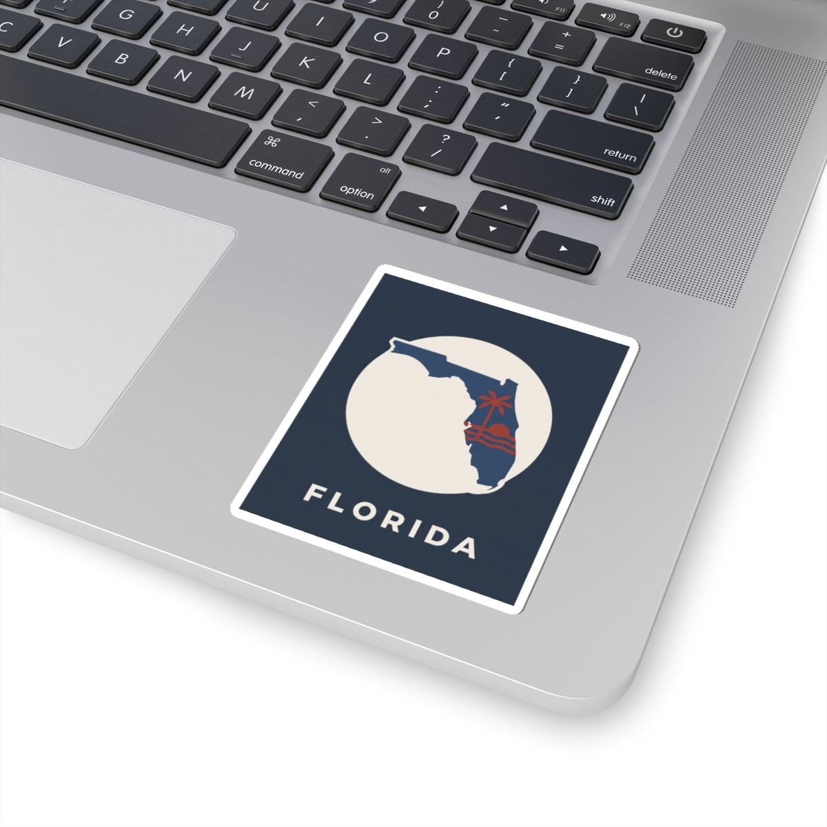 Florida state sticker on laptop: blue square with white circle, red palm tree and 'FLORIDA'