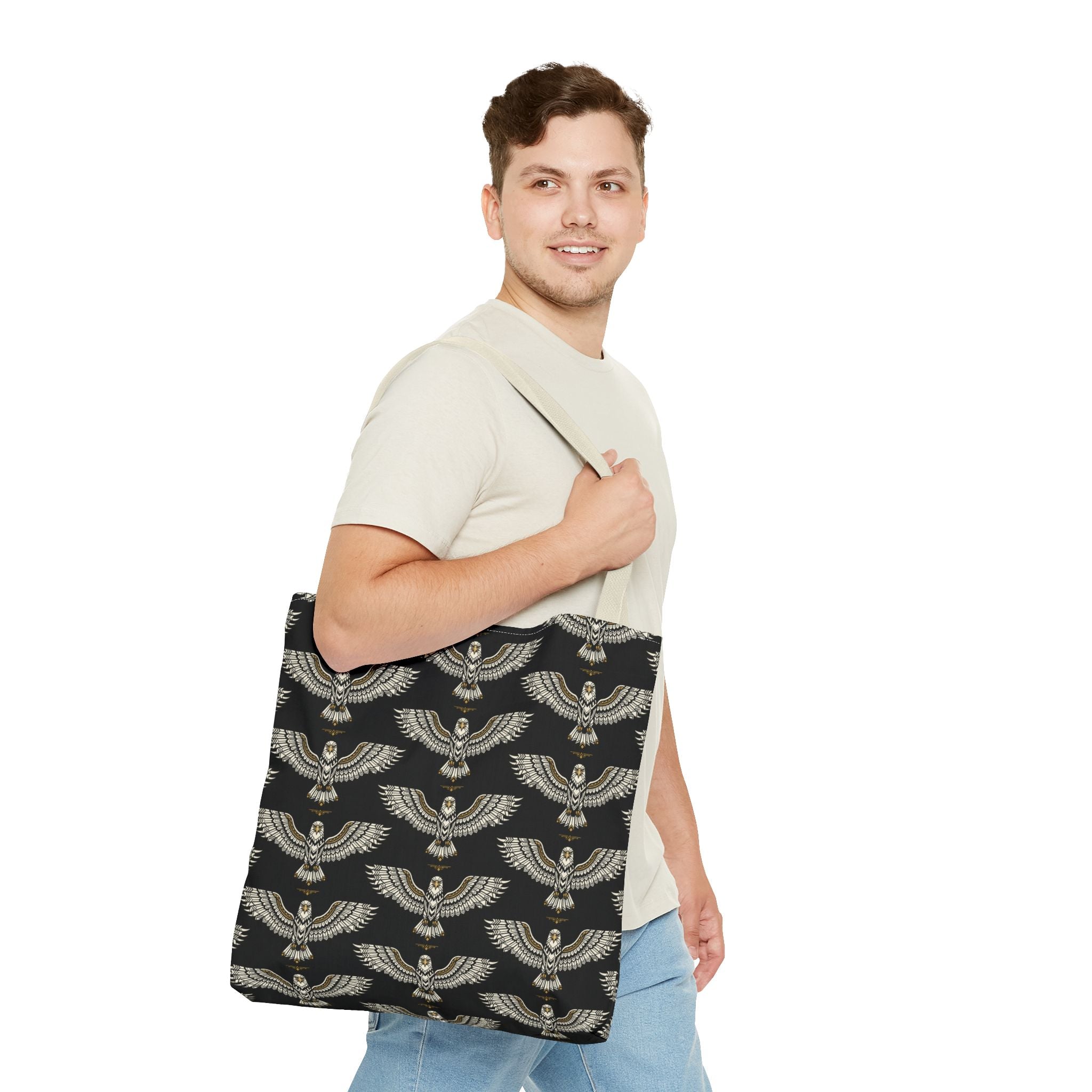 Black winged scarab tote bag with pale gold repeating motif; wide shoulder carry handles