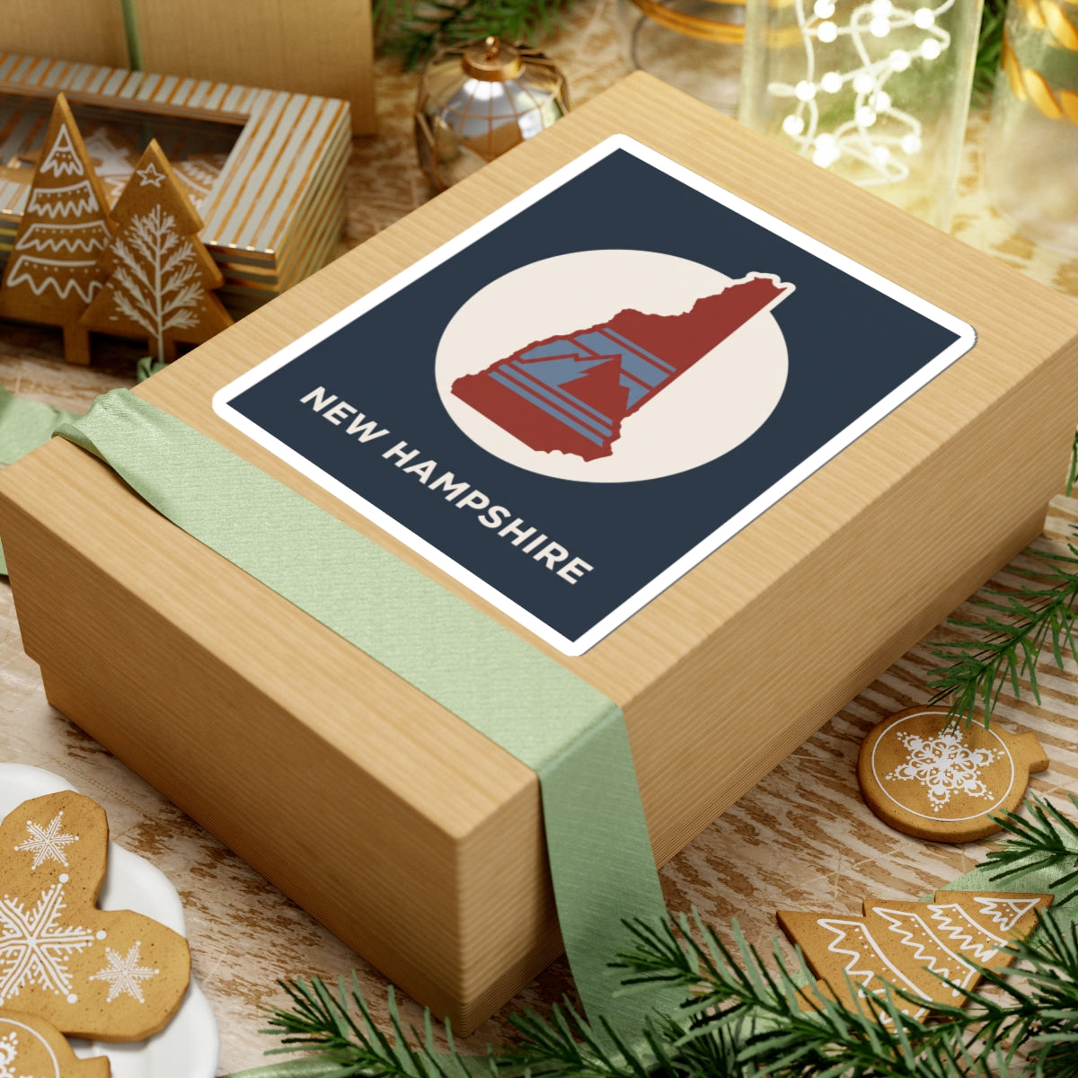 New Hampshire state silhouette sticker on a gift box: navy sticker with red NH map and text