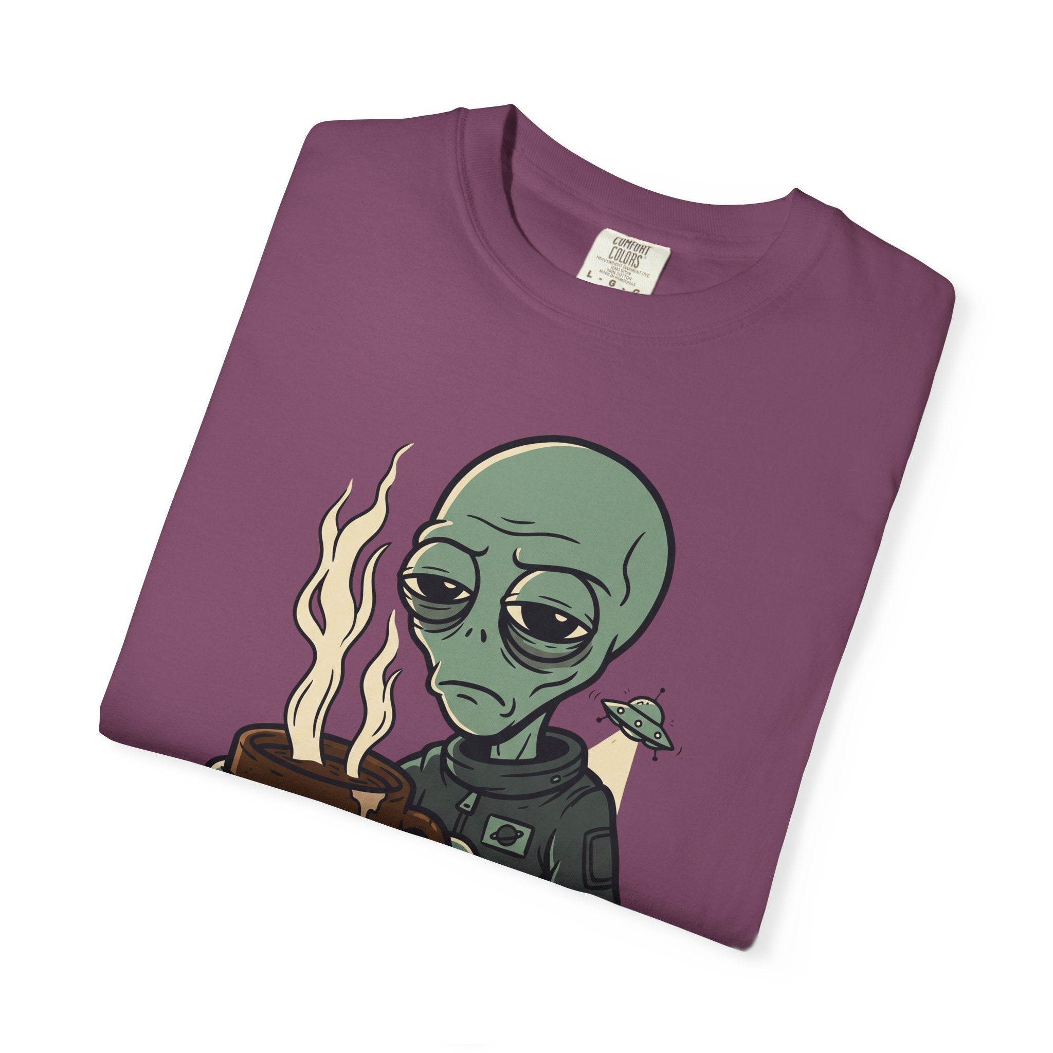 Dark purple T-shirt folded with green alien holding coffee, flames, and “PROBE ME”