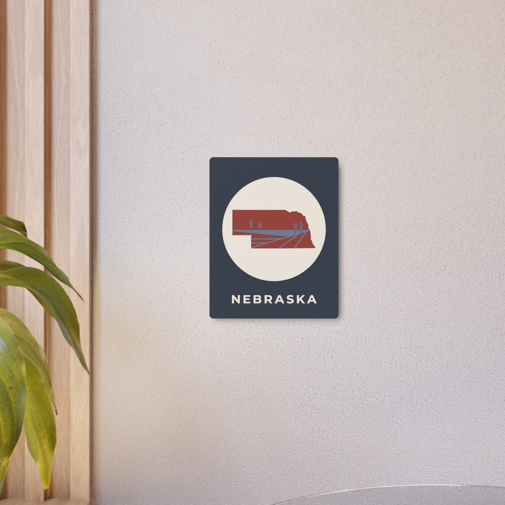 Small Nebraska state metal wall sign with circular farm graphic and “NEBRASKA” text