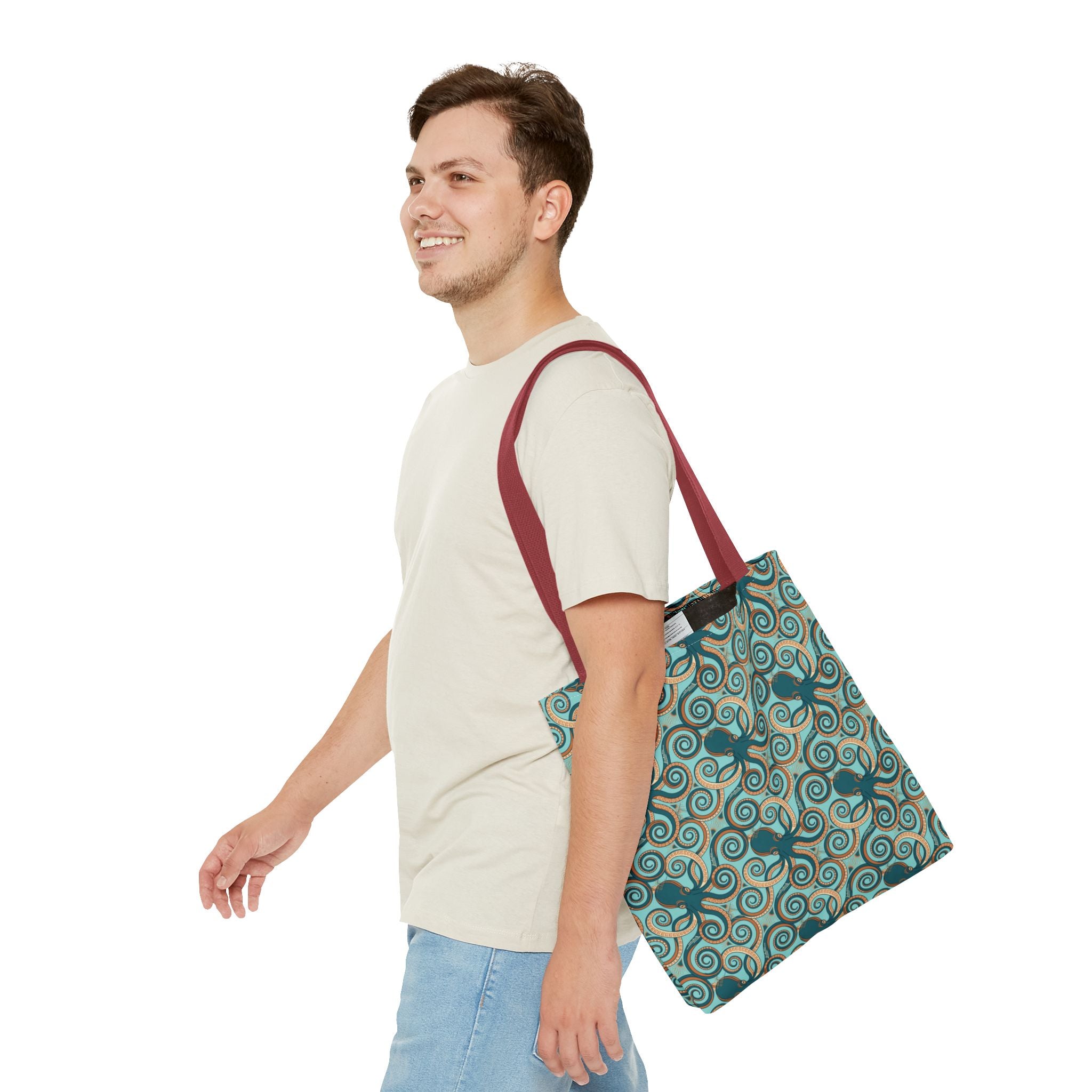 Teal octopus swirl tote bag with red strap on shoulder