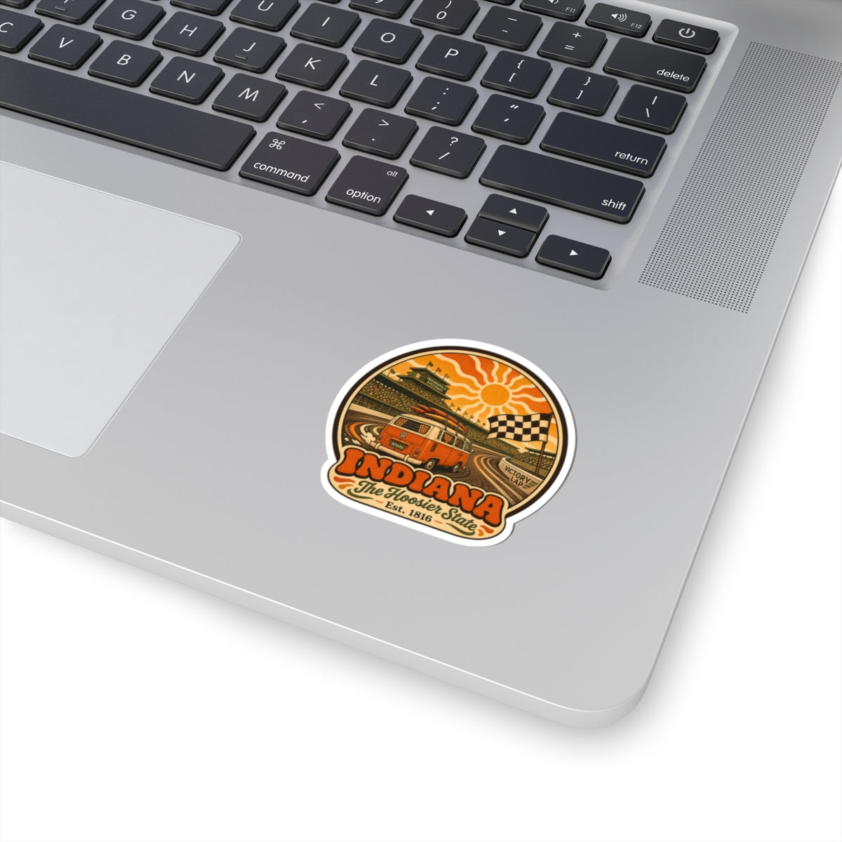 Circular sticker with vintage racing van, orange sun, and checkered track design