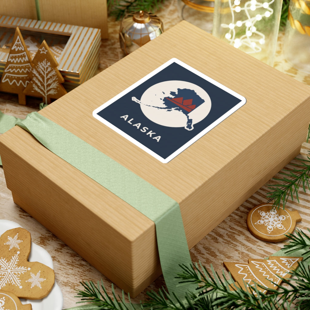 Square Alaska map badge sticker on a wrapped gift, retro mountain in red and navy