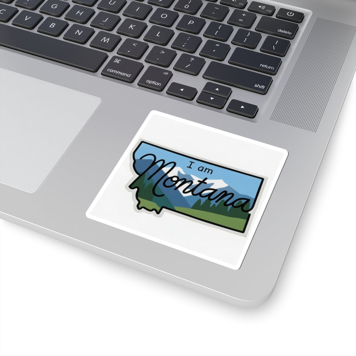 Die-cut “I am Montana” sticker on white backing, blue sky and green mountain shapes