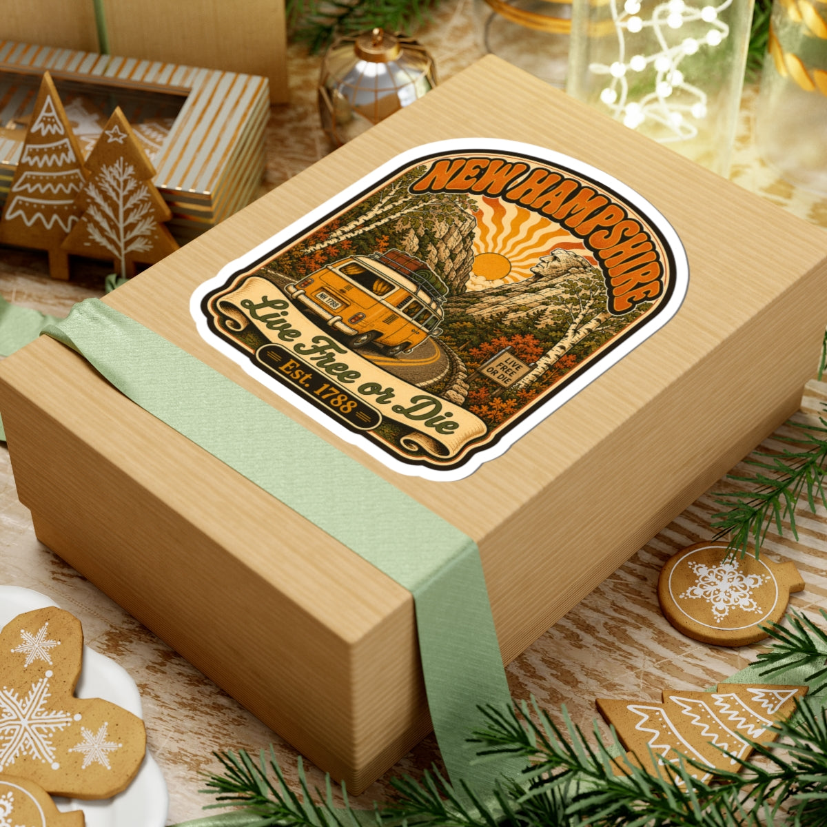 Round kiss-cut New Hampshire camper van sticker with evergreen trees, sunrise, and “Live Free or Die”