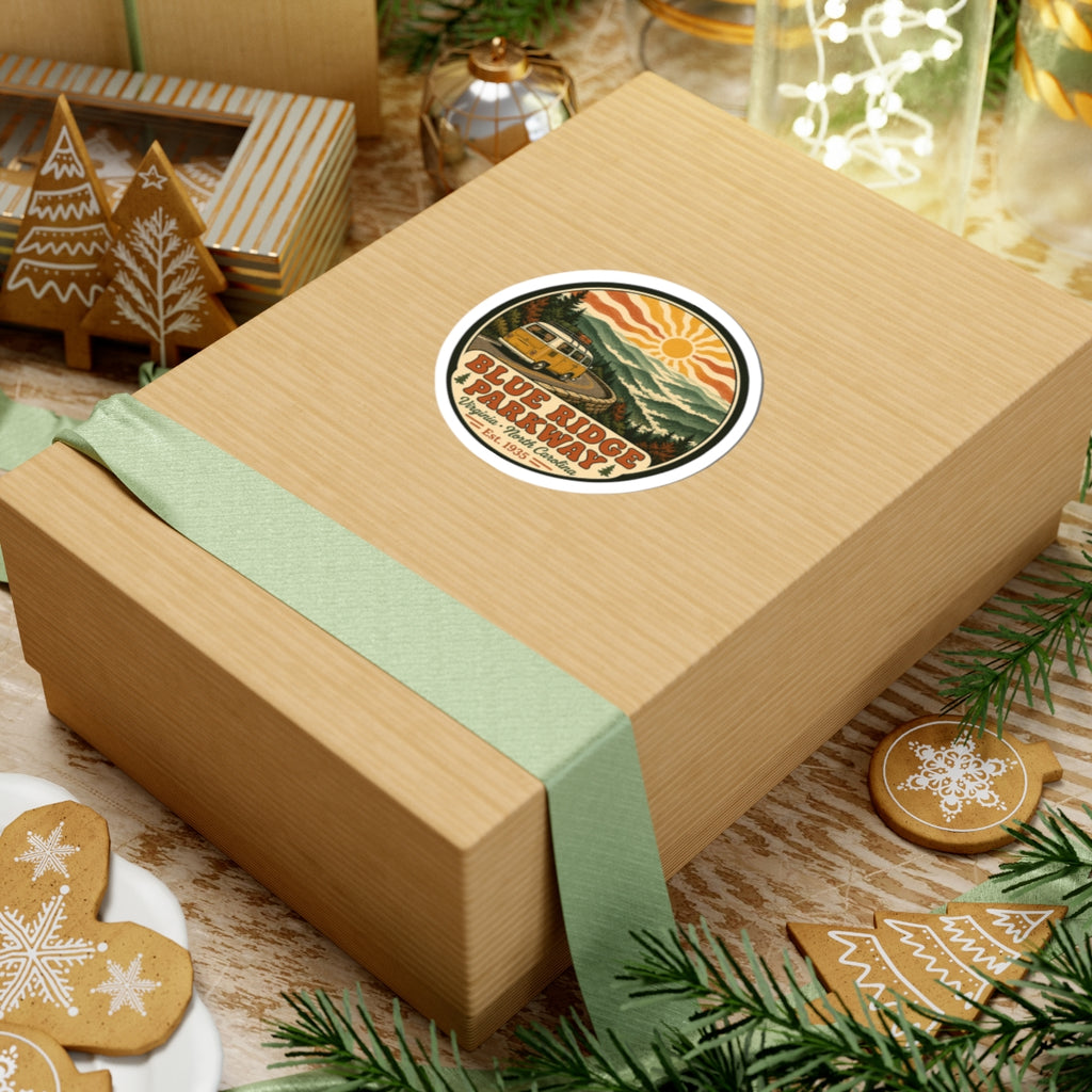 Circular Blue Ridge Parkway sticker on a gift box: yellow camper van, mountains, sun and text
