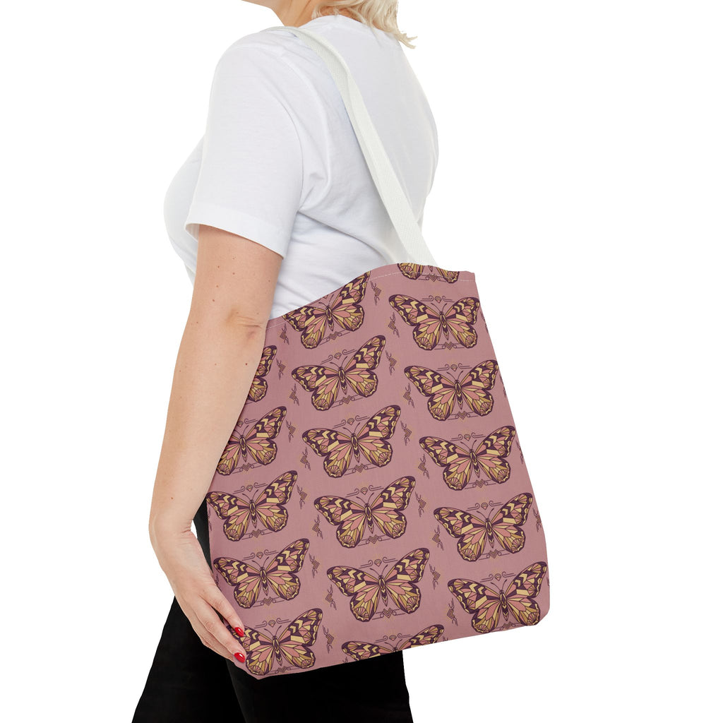 Pink butterfly print tote bag with light handles on the shoulder, back view.