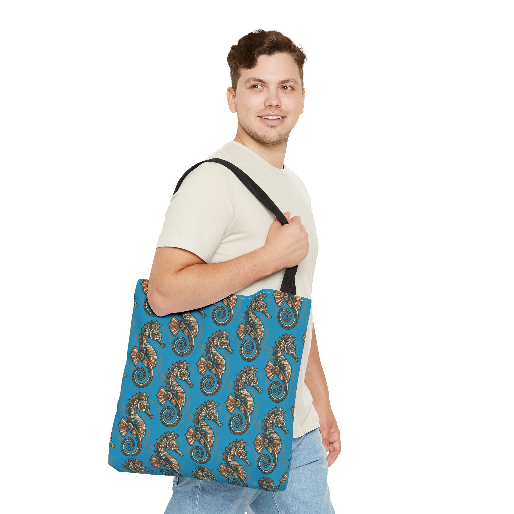 Tote bag worn on shoulder in blue with seahorse pattern and black straps