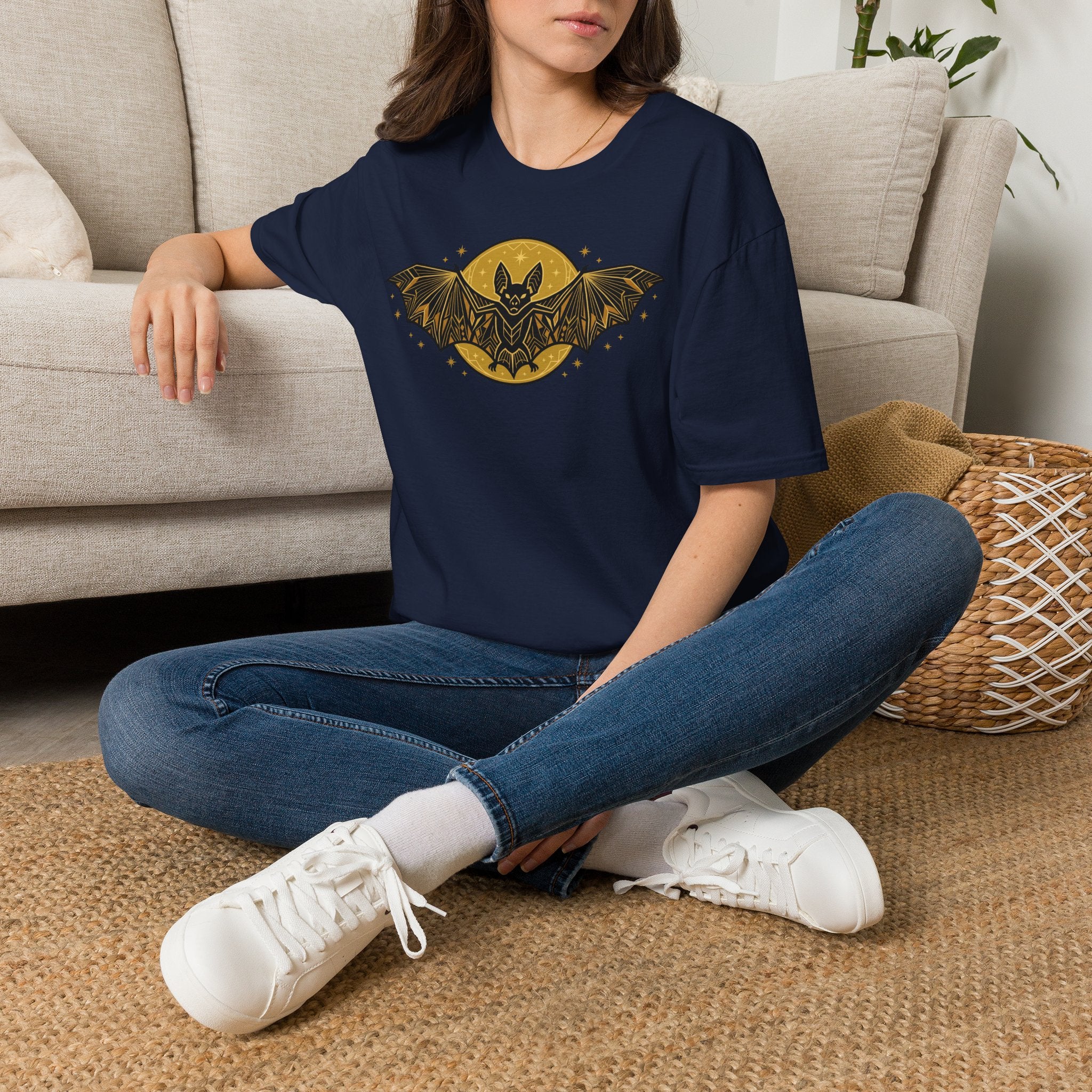 Navy T-shirt worn with gold bat and moon graphic on the chest
