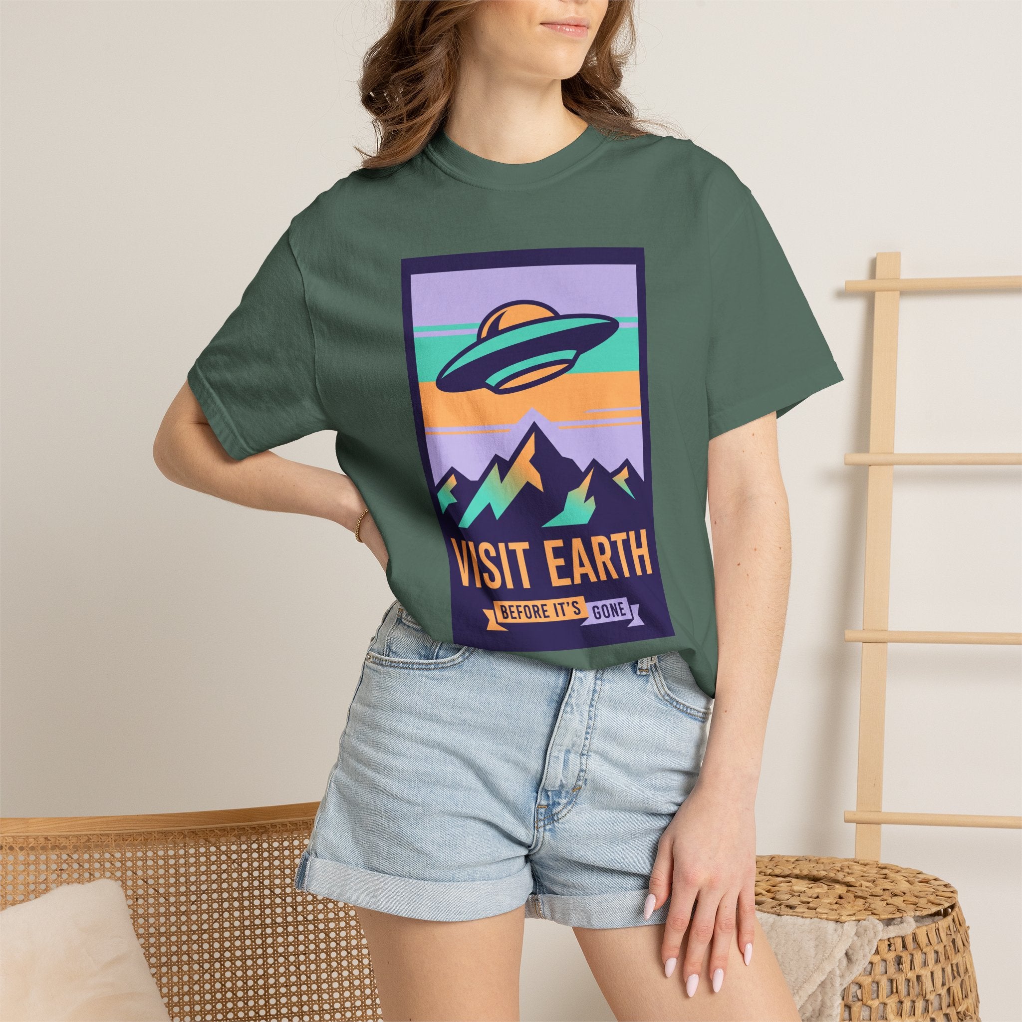 Dark green T-shirt with square UFO poster graphic and 'VISIT EARTH' text.