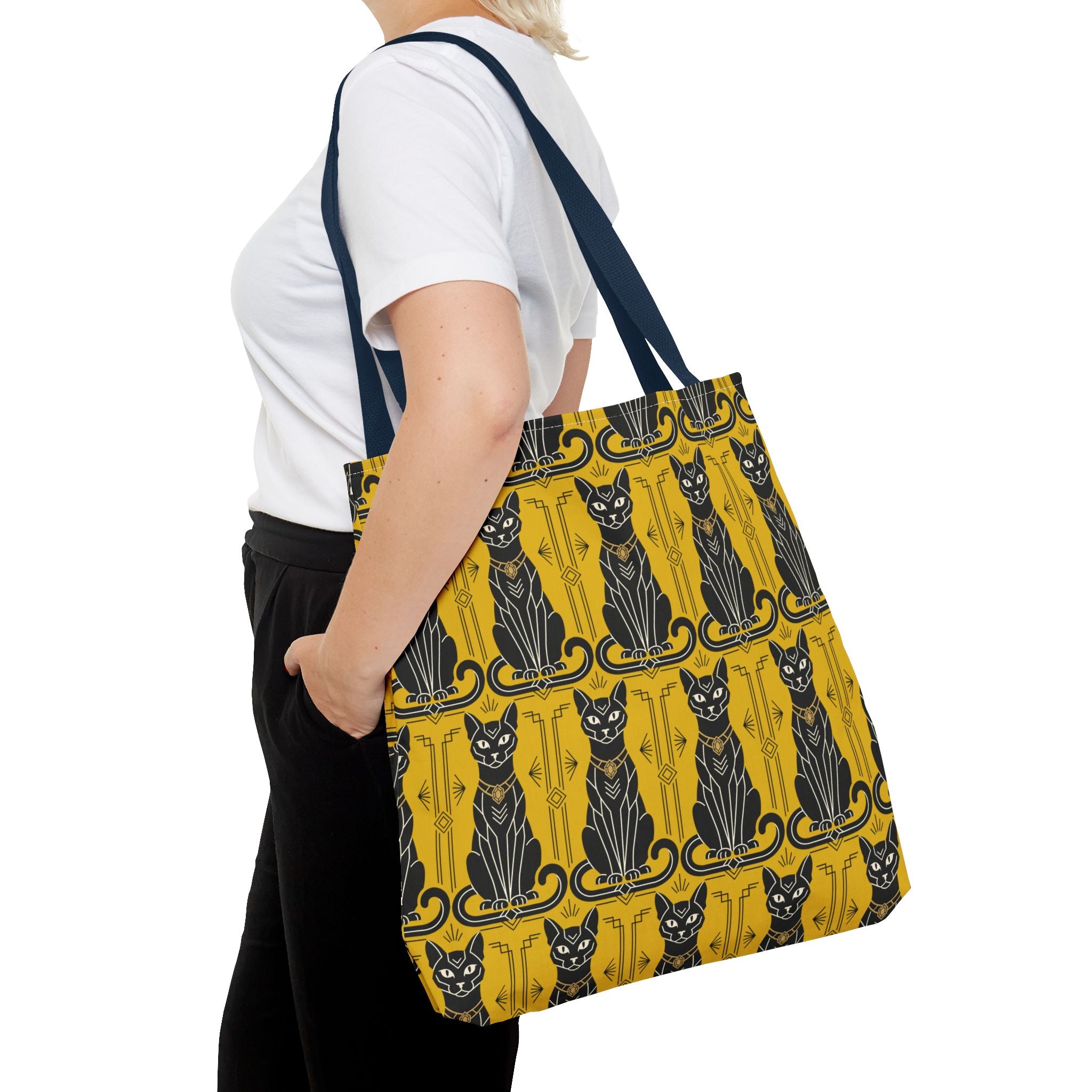 Yellow tote bag with black cat pattern and navy handles, worn by model