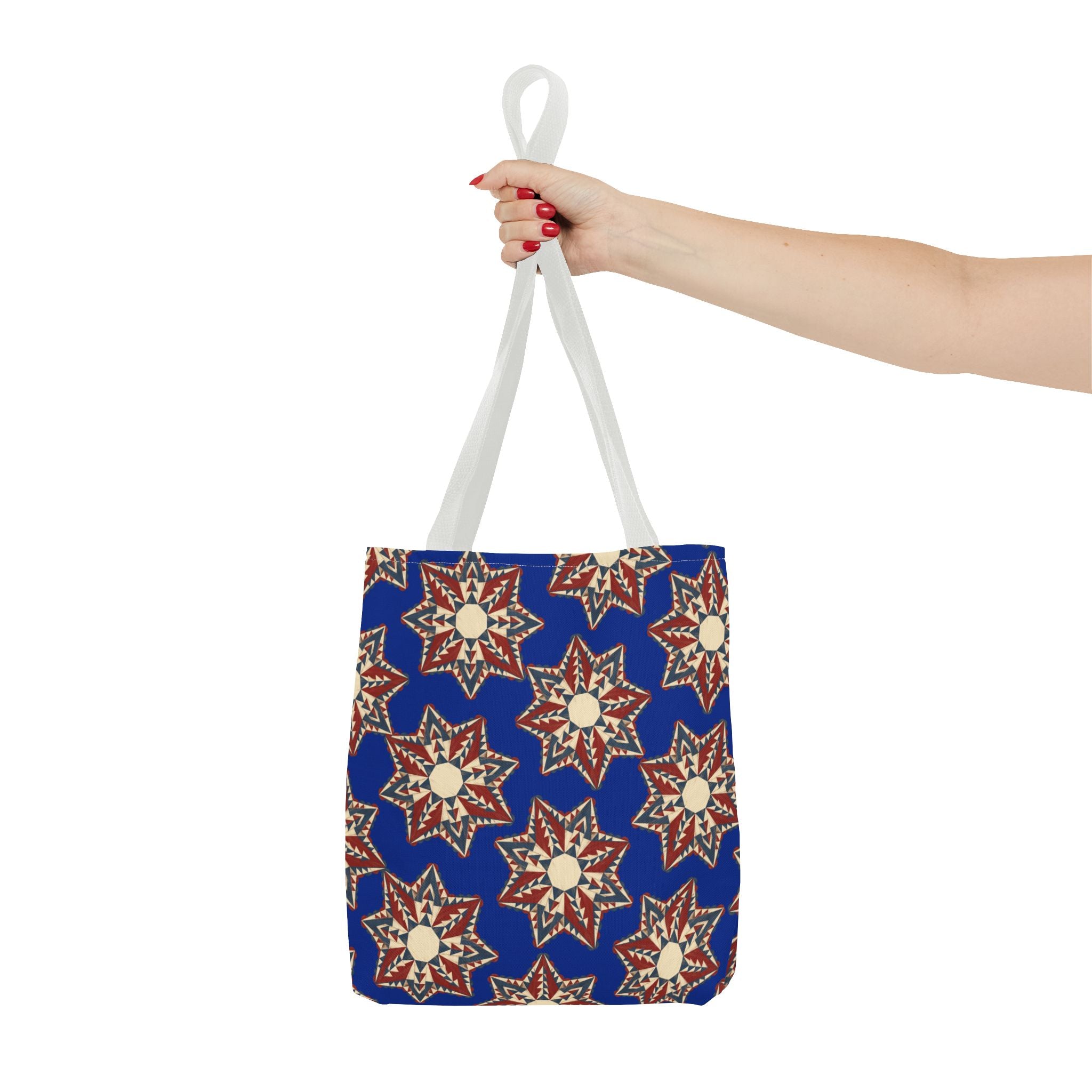 Blue starburst floral tote bag with white handles held up by one hand