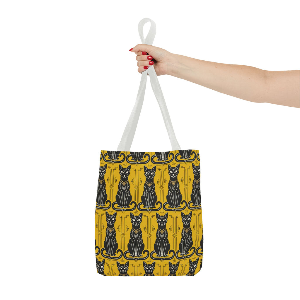 Yellow cat-pattern tote bag with black cats and navy swirls, held up by white handles.