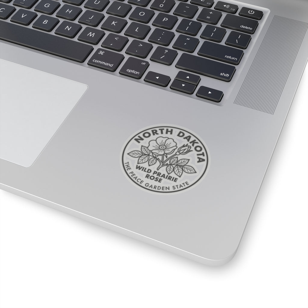 Transparent sticker on laptop lid showing North Dakota wild prairie rose garden state emblem