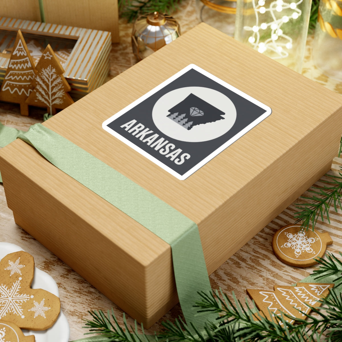 Arkansas vinyl sticker on wrapped gift: black state silhouette with diamond trees, ARKANSAS