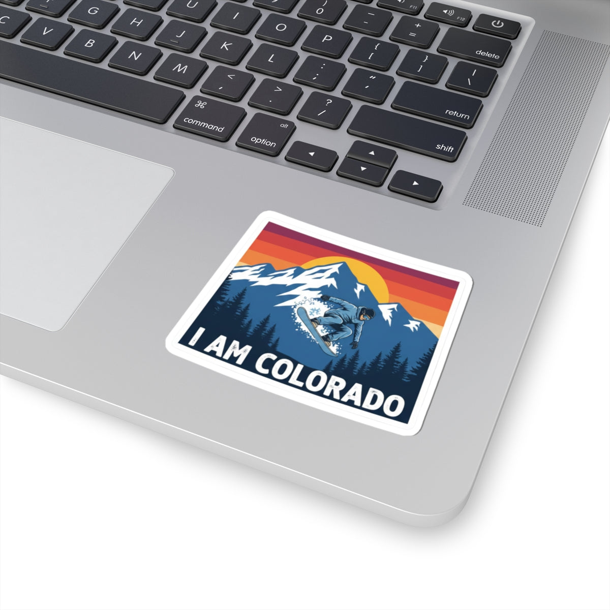I Am Colorado sticker on laptop, snowboarder scene with pine trees and “I AM COLORADO”