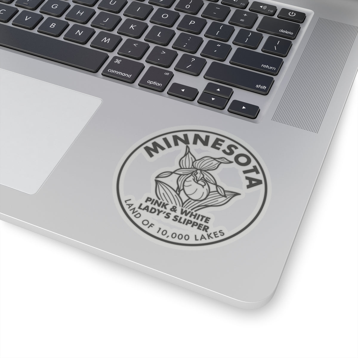 Minnesota Pink & White Lady’s Slipper sticker on laptop lid, close-up round emblem