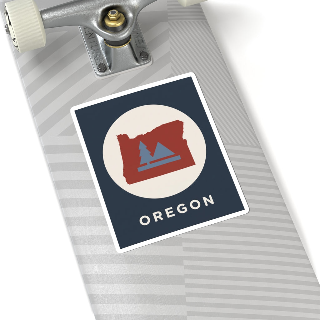 Square Oregon state sticker with red map, blue fir trees and mountains; OREGON text.