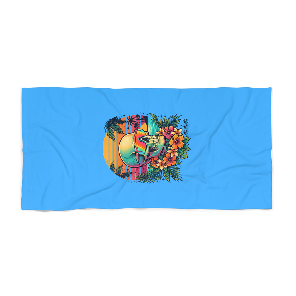 Blue beach towel with skull in sunset-style colors and palm-leaf accents