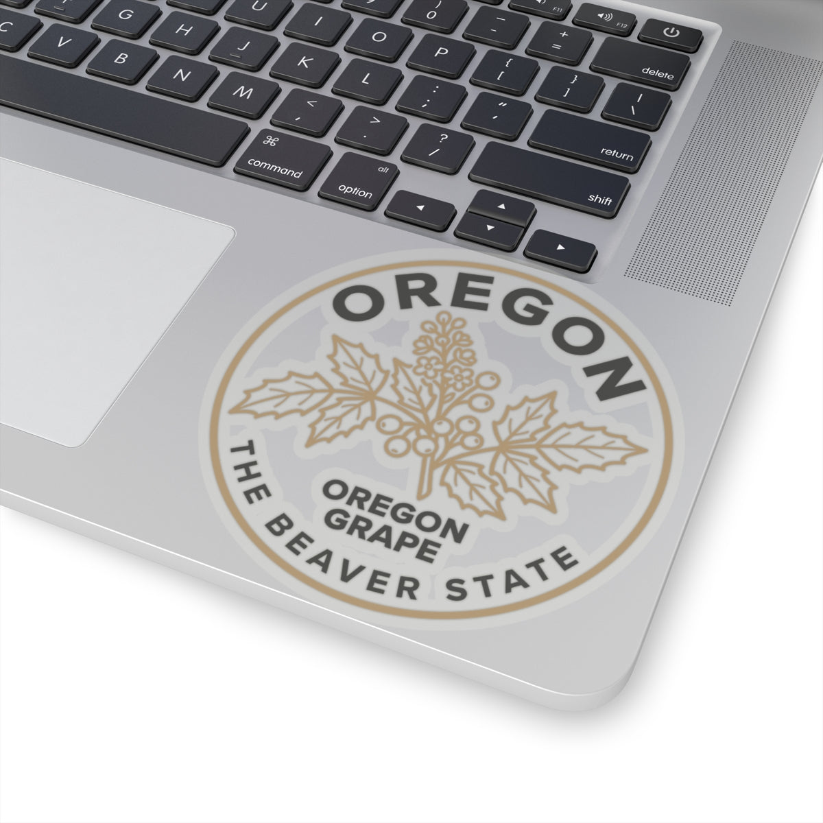 Circular Oregon grape sticker on laptop lid, showing grape leaves and 'OREGON GRAPE BEAVER STATE'