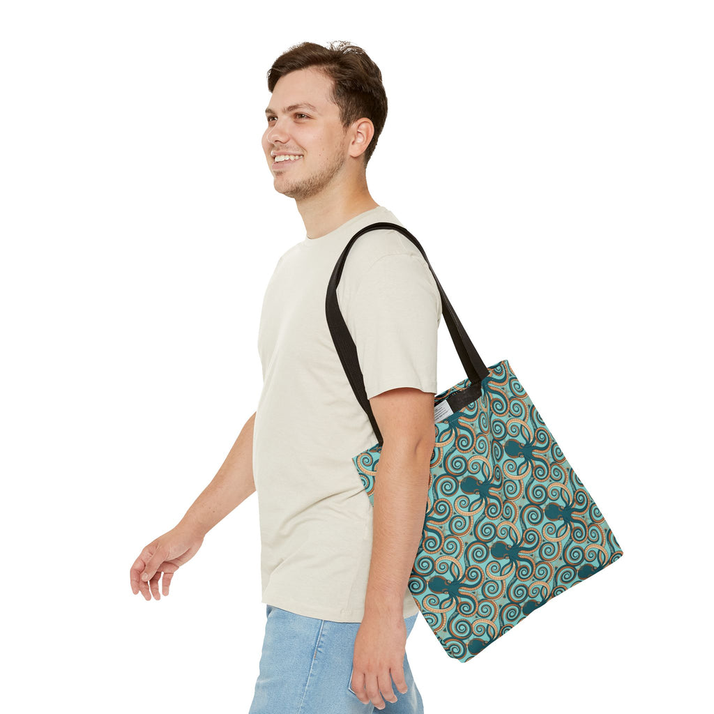 Octopus swirl tote bag with teal all-over print, carried crossbody, black handles