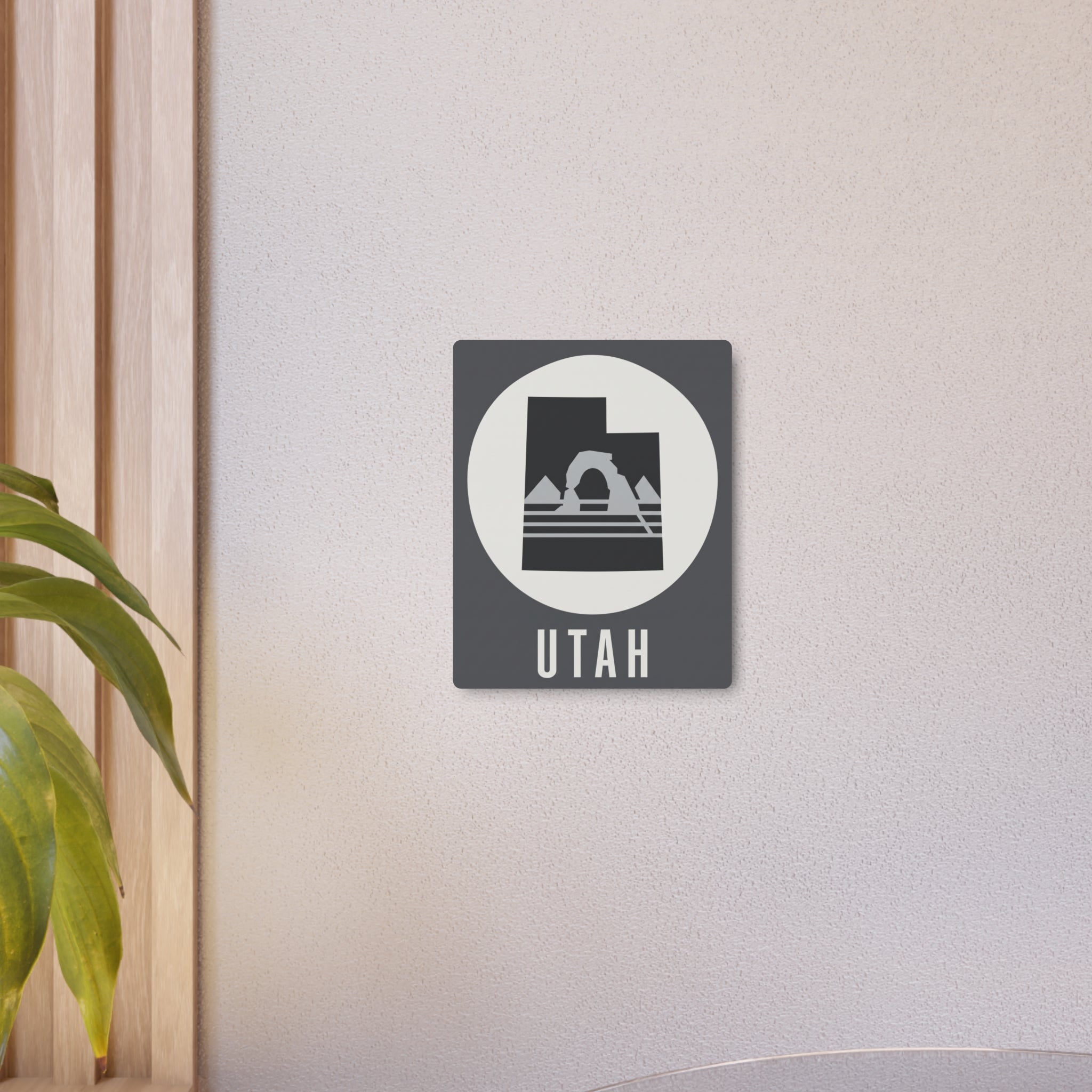 Utah metal wall art sign mounted on wall, dark square with white circle and mountain silhouette