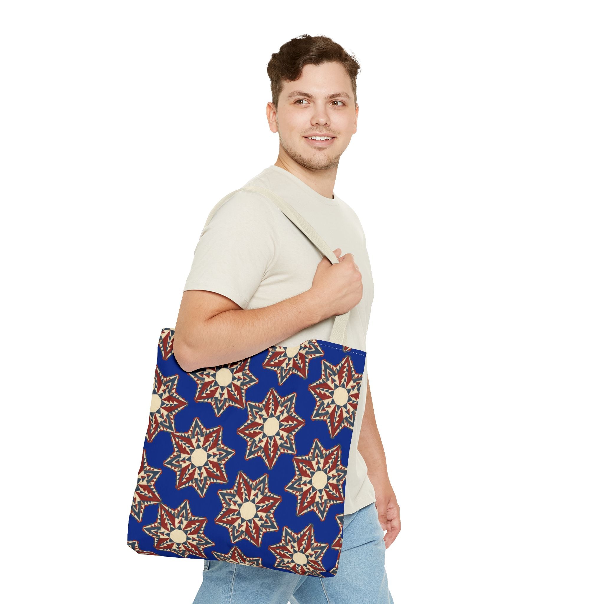 Blue canvas tote bag with cream and red starburst floral pattern, light straps and handles