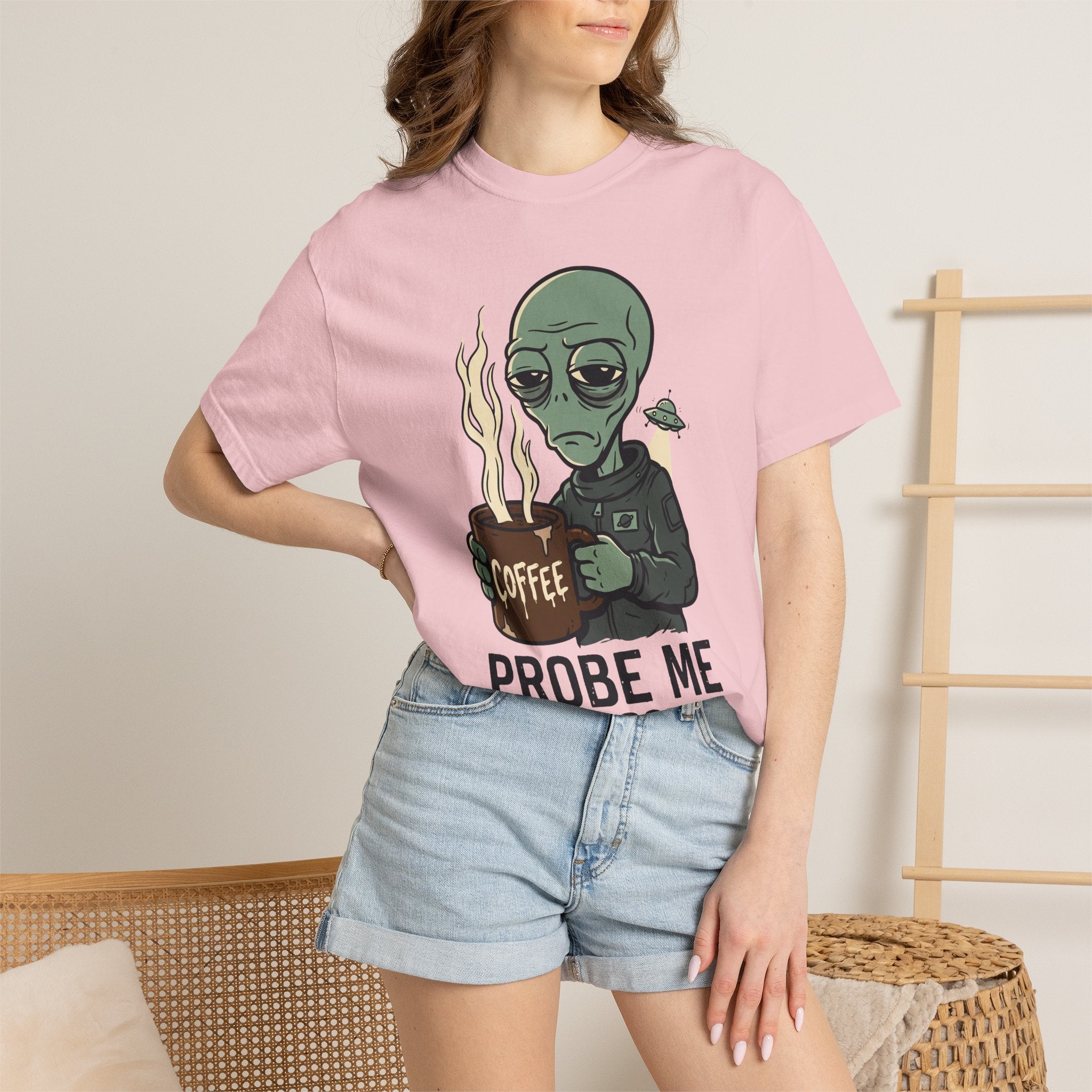 Light pink T-shirt on model with green alien holding coffee and “PROBE ME” graphic