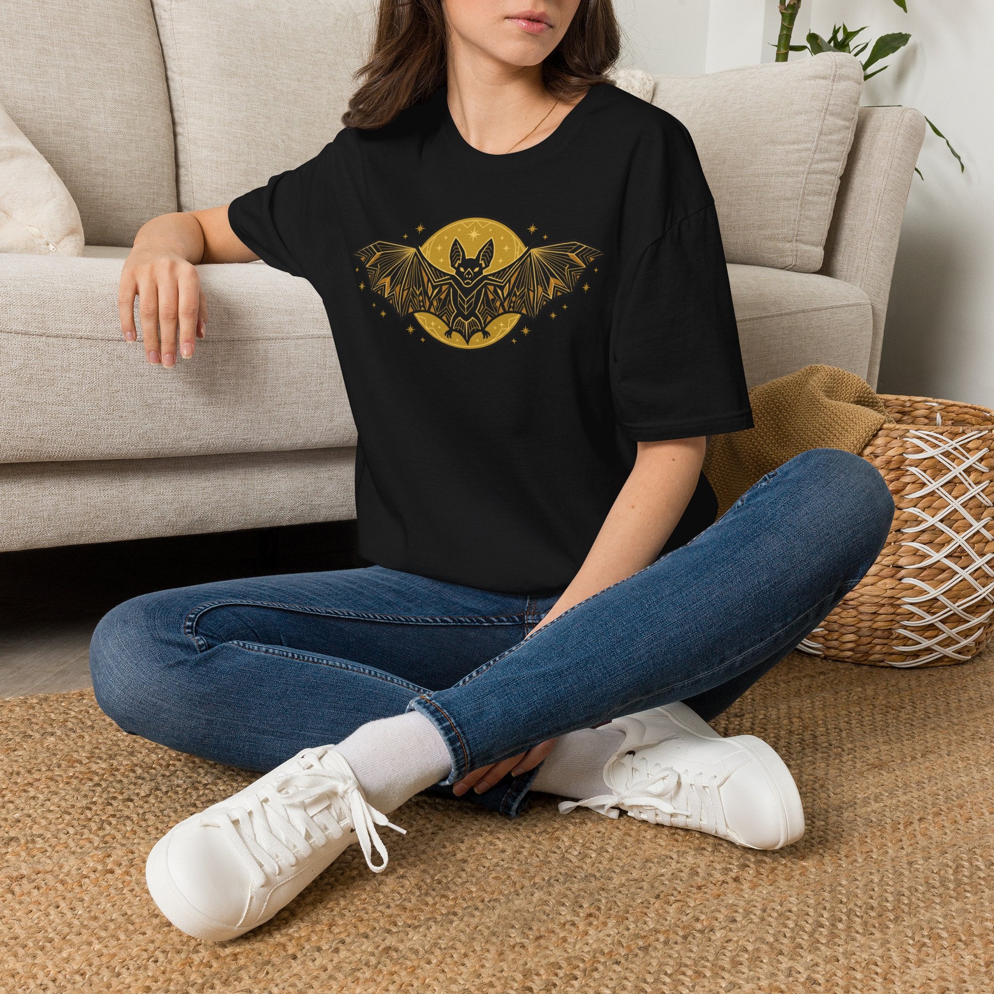Black crew-neck t-shirt with gold bat-and-moon graphic on front