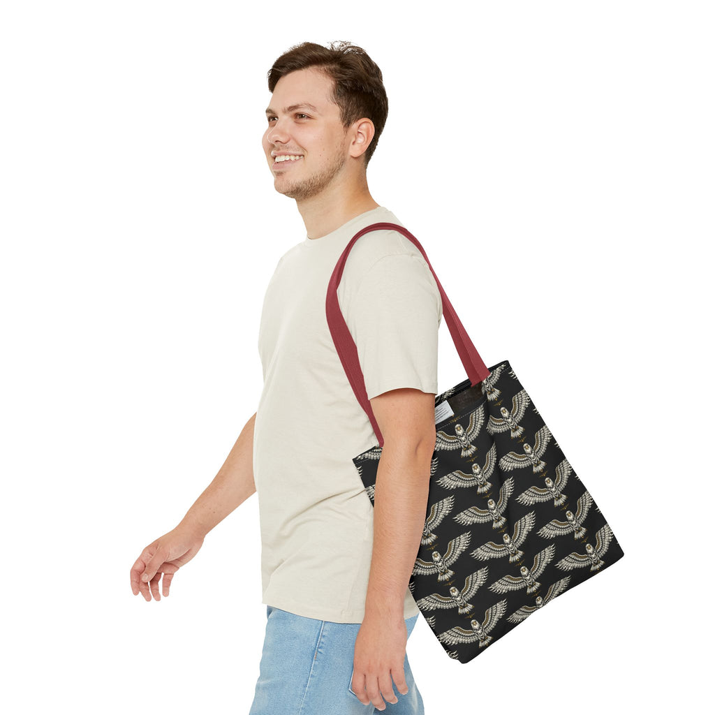 Tote bag carried on shoulder, black fabric with gold winged scarab pattern, maroon handles