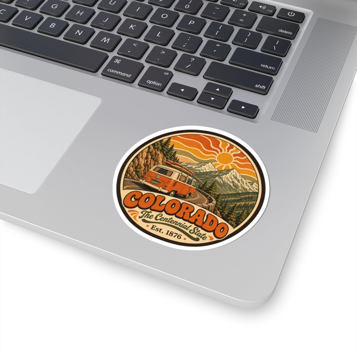 Round Colorado camper van sticker on a laptop lid with keyboard edge visible