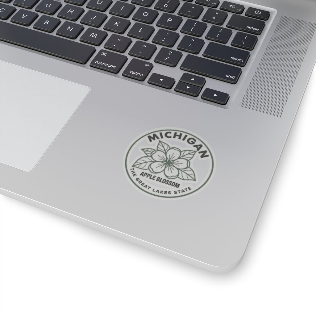 Transparent vinyl Michigan apple blossom sticker on laptop lid, round gray seal design