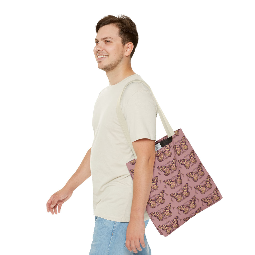 Pink butterfly tote bag with light beige handles, carried by a man
