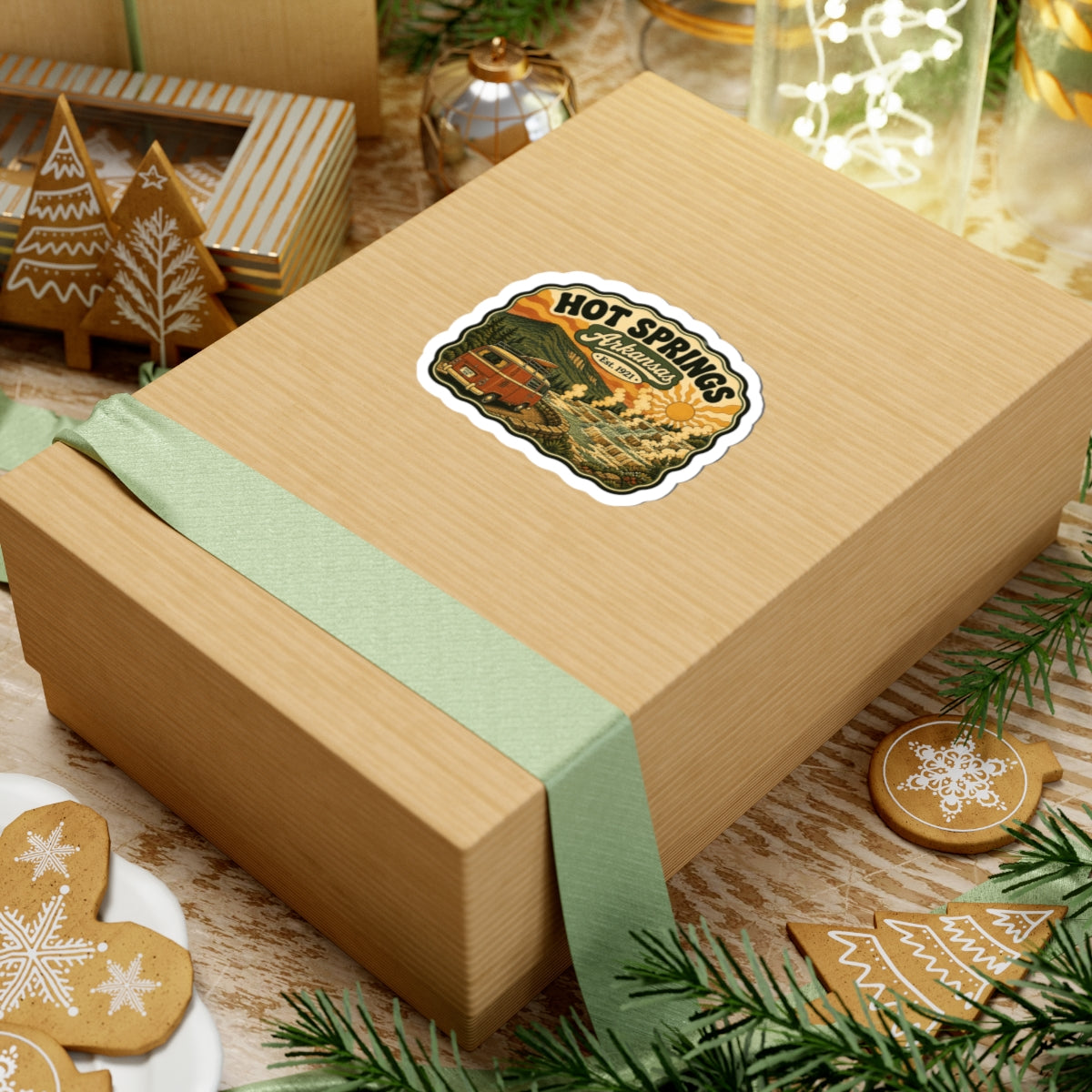 Die-cut Hot Springs Arkansas sticker on a wrapped gift box with vintage camper van landscape