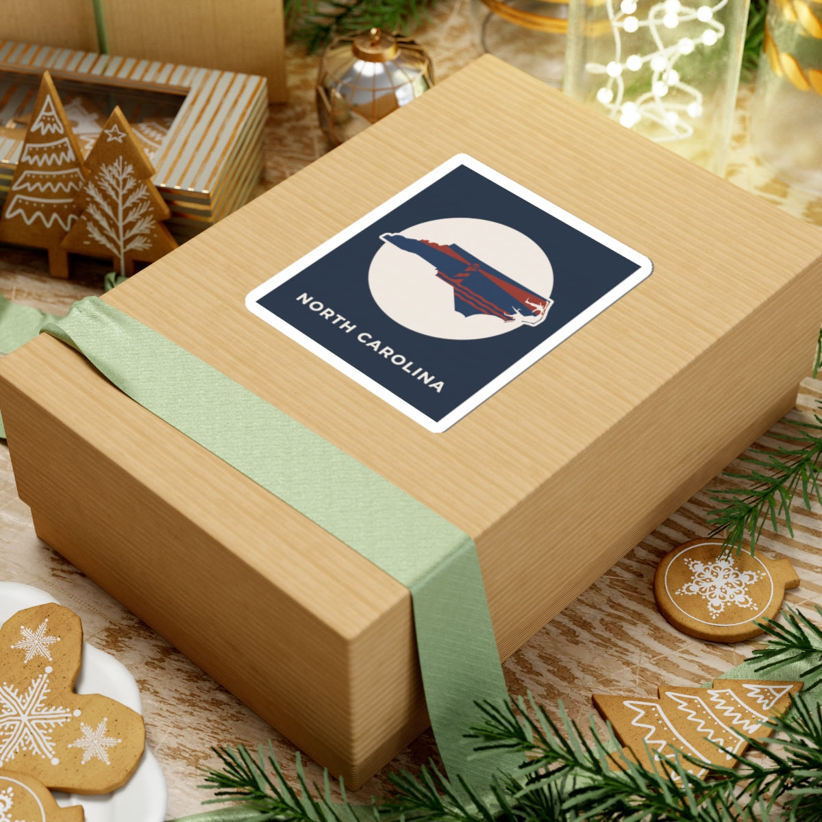North Carolina state kiss-cut sticker on a gift box, navy square with state silhouette