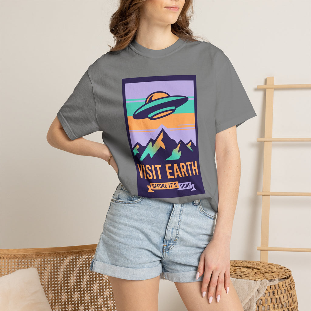 Dark gray T-shirt on model with framed 'Visit Earth' UFO poster graphic