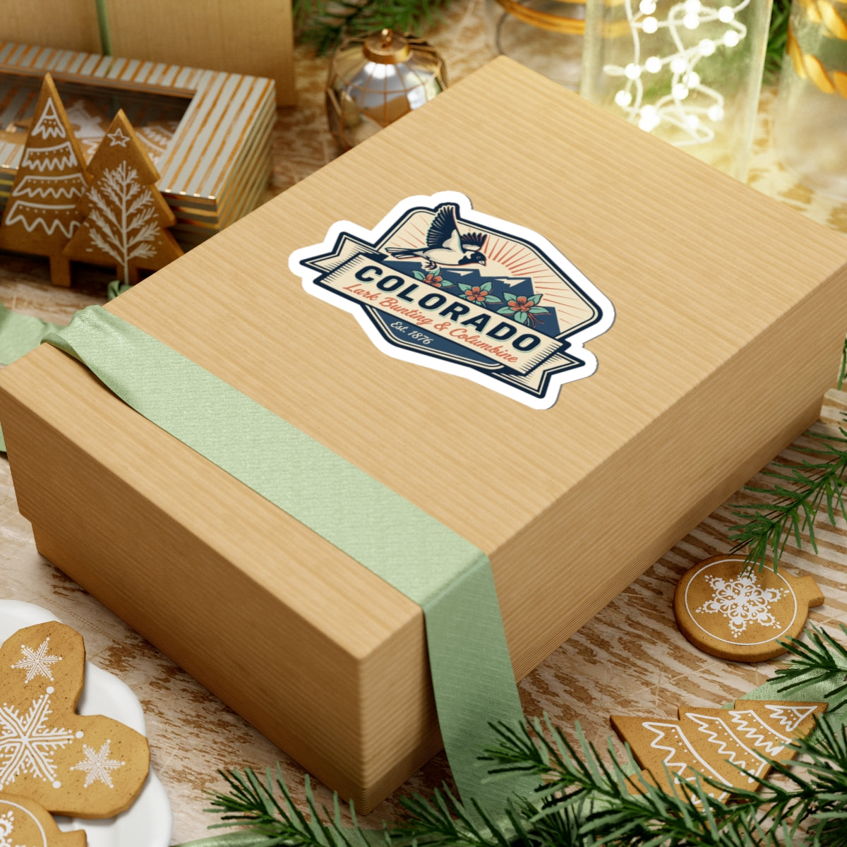 Colorado sticker decal on a wrapped gift box with ribbon bird badge and floral accents