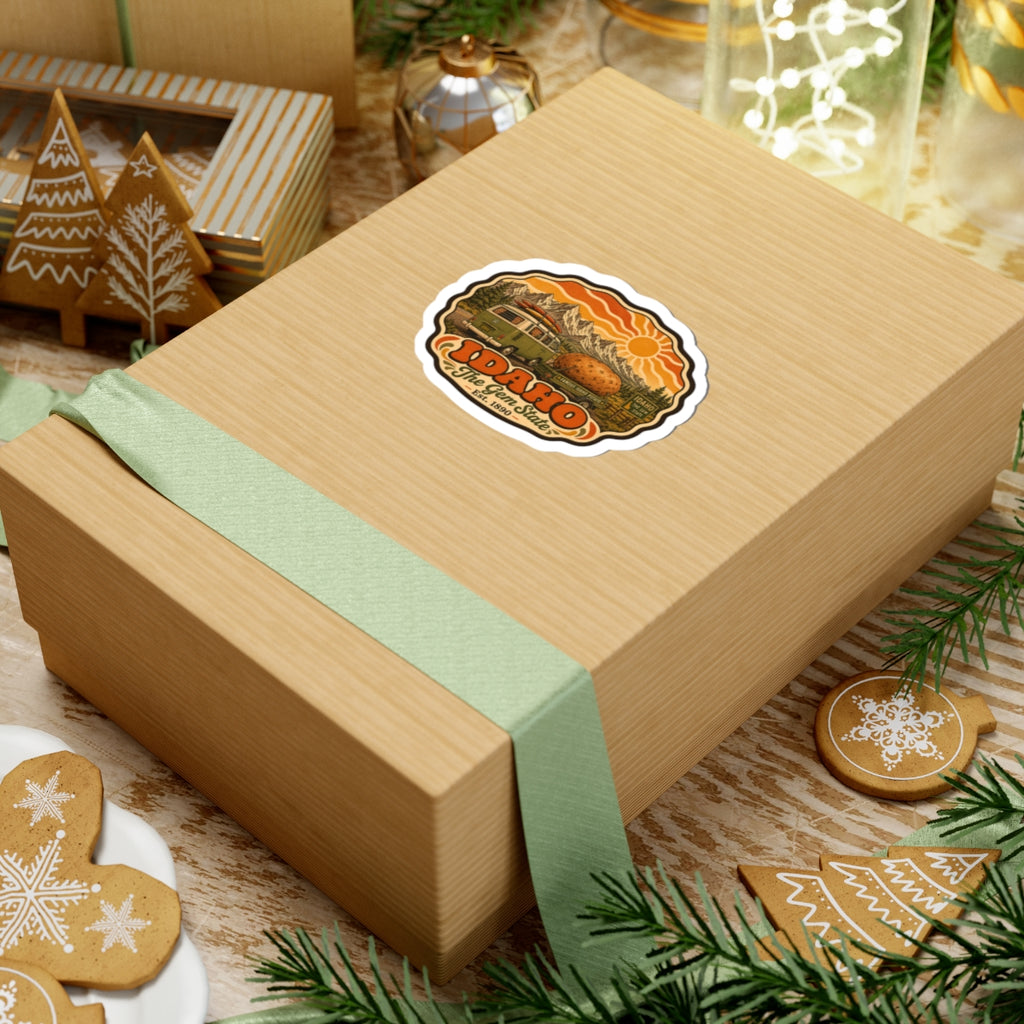 Idaho vintage roadtrip sticker on a gift box, featuring green van, potato, mountains and sun.