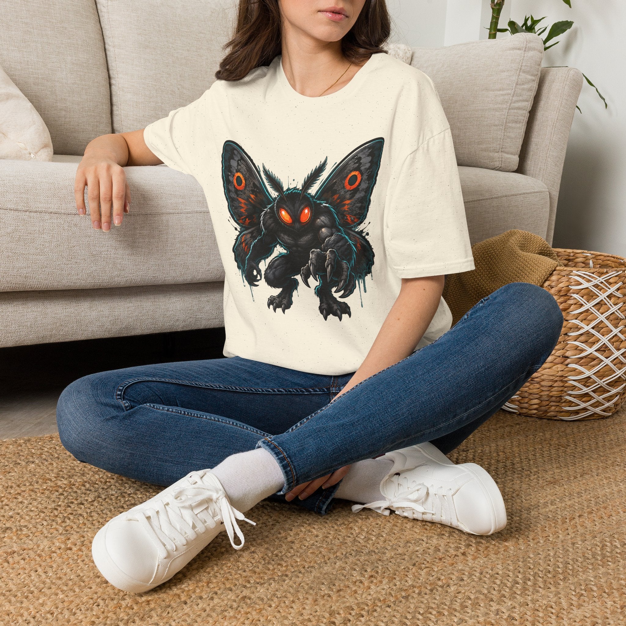 Cream crewneck T-shirt with glowing-eyed moth monster front graphic