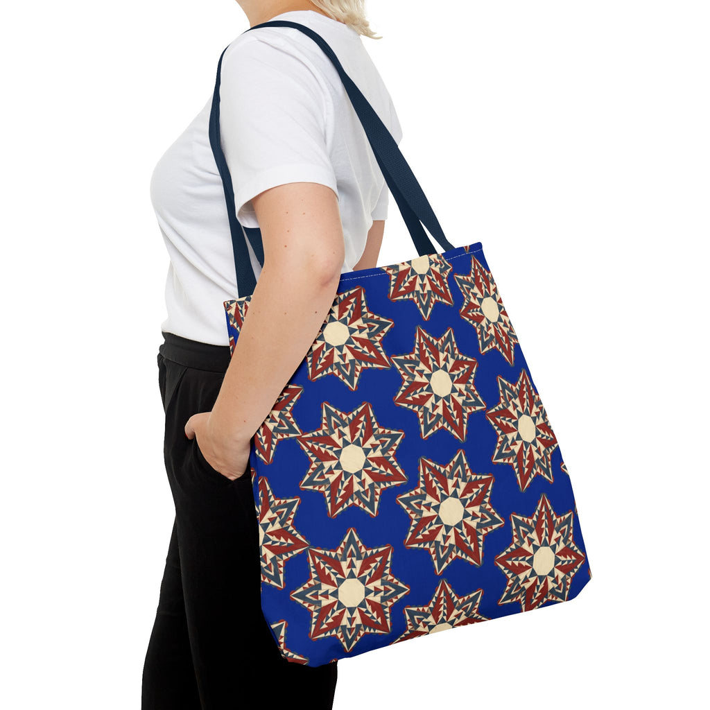 Navy tote bag with red and cream starburst floral pattern, long shoulder strap and handles.