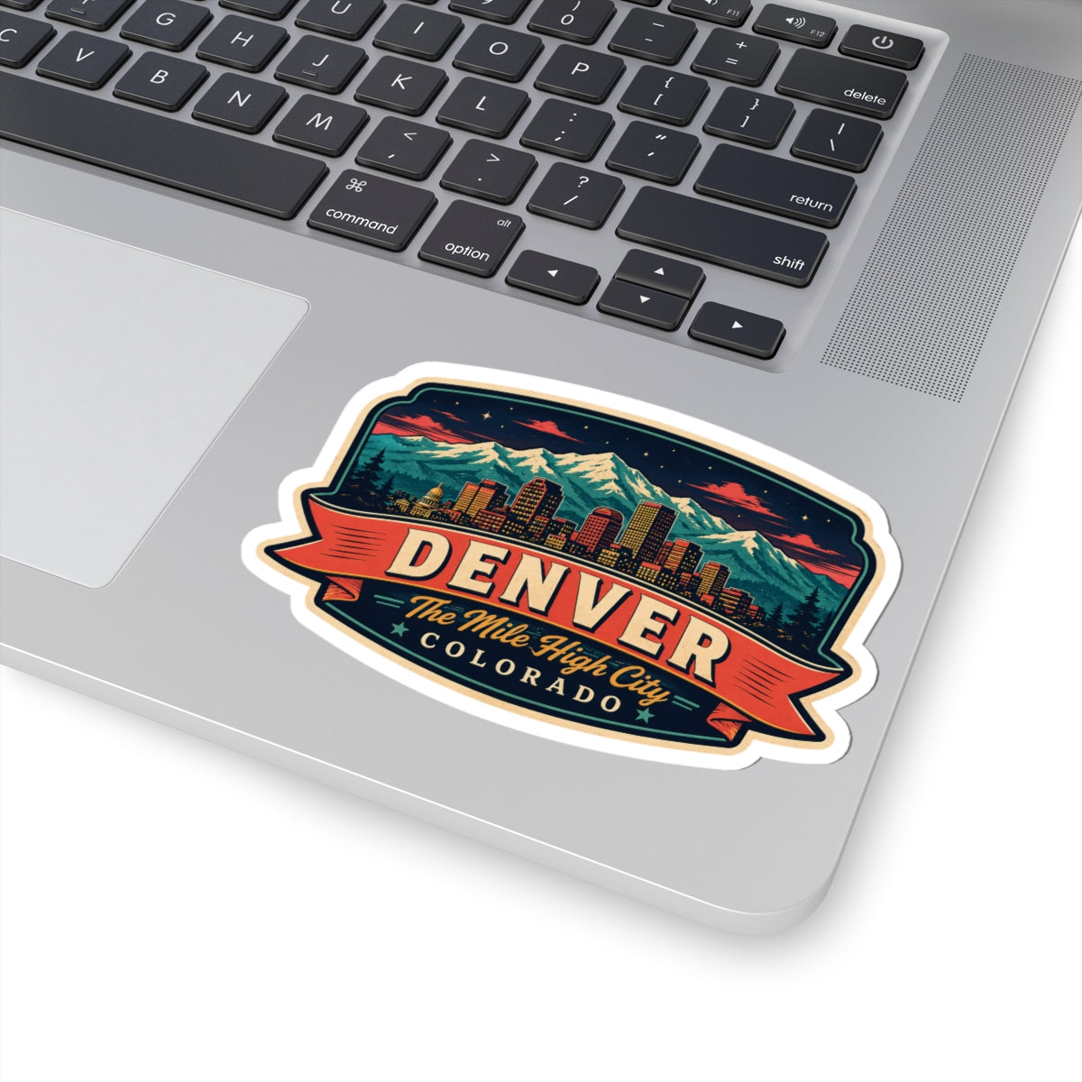 Luggage tag sticker on laptop lid with Denver skyline mountains and “Mile High City”