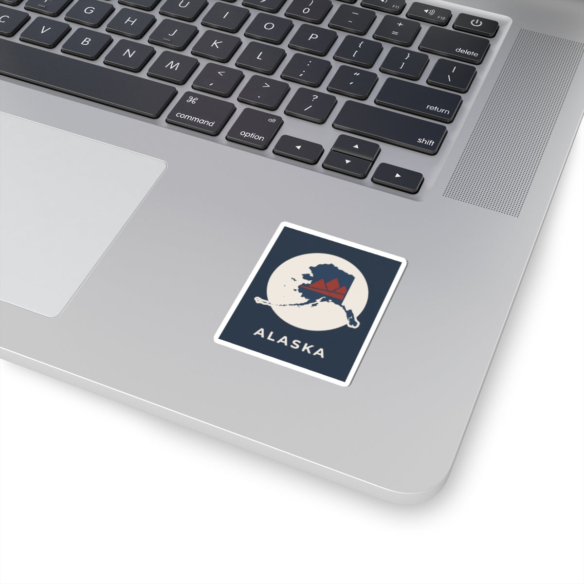 Alaska state map sticker with navy badge, 'ALASKA' text, and cutout border