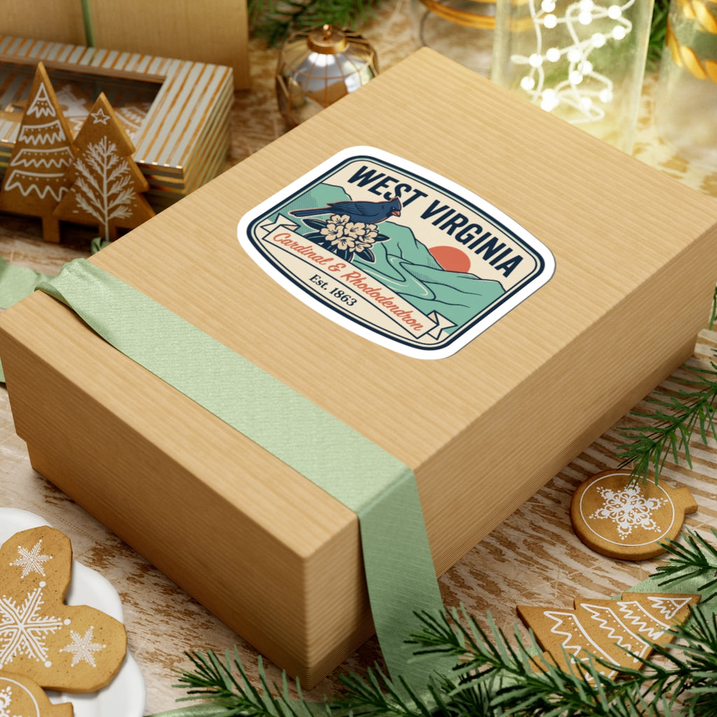 West Virginia badge sticker on a wrapped gift box, cardinal and rhododendron, Est. 1863.