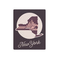 Square metal wall art with circular New York skyline silhouette and script “New York”.