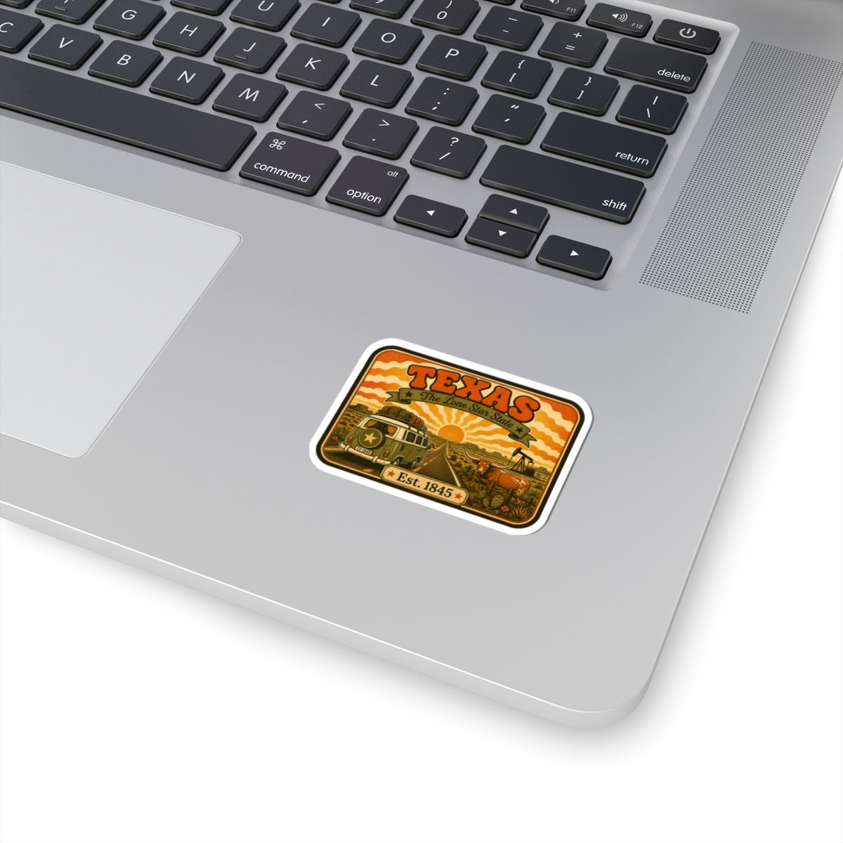 Kiss-cut Texas road trip sticker with retro wagon and desert scene, on light surface